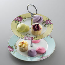Load image into Gallery viewer, A grey background. This is an image of the Aynsley Archive Rose 2 Tier cake stand holding petit fours and lilac, lemon and pink coloured macarons. The tops plate has a yellow border. The bottom plate has a blue border. Both plates have pink rose and green leaf motifs. The pieces holding the cake stand together are silver in colour.