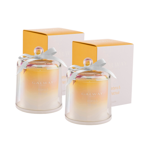 A pair of filled glass candles with glass bell jar lid. They come in their own gift box. They are a yellow ombre with an iridescent finish. 