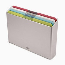 Load image into Gallery viewer, A slimline, silver casing which houses 4 colour coded large cutting boards. They are red, white, blue and green.
