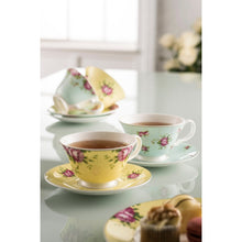 Load image into Gallery viewer, A lifestyle image of Aynsley Archive Rose set of 4 teacups and saucers. 1 yellow and 1 blue are to the fore, on a white reflective worktop. Filled with black tea.

