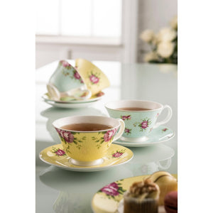 A lifestyle image of Aynsley Archive Rose set of 4 teacups and saucers. 1 yellow and 1 blue are to the fore, on a white reflective worktop. Filled with black tea.