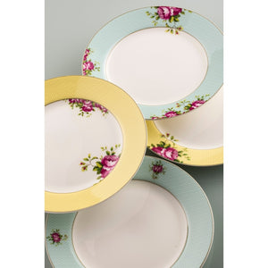 This is a close up of 4 Aynsley Archive Rose Fine China Side Plates. 2 have a blue border, with pink roses and green leaves motif. 2 have a yellow border. 1 yellow border plate has pink roses and green leaves motifs on the border and 1 has them on the inside of the border on the white plate center. All plates have a white center.