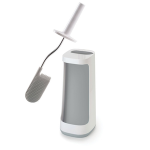A large white stand which houses the brush, also has a front caddy compartment suitable for holding a bottle of toilet cleaner (example only). The brush has a white plastic handle, a stainless steel rod and a head of light grey silicone. The bristles are designed to be anti-clog as any water or debris will fall through the bristles.
