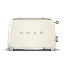 Load image into Gallery viewer, A front view. White Background. Cream Smeg Retro 50&#39;s style 2 slicer toaster. It has a cream body, Chrome top and base with chrome embossed letters S M E and G across the front. The push down lever, browning knob, defrost, reheat and stop buttons are all chrome.
