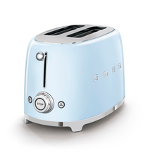 Load image into Gallery viewer, White Background. Smeg 2 slice 50&#39;s retro toaster. The body is Pastel blue and it is chrome at the top and bottom. There are chrome S M E and G letters embossed on the front and back. The push down leaver, browning knob, defrost, reheat and stop buttons are all chrome.
