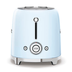 A side view. White Background. Smeg 2 slice 50's retro toaster. The body is Pastel blue and it is chrome at the top and bottom. There are chrome S M E and G letters embossed on the front and back. The push down leaver, browning knob, defrost, reheat and stop buttons are all chrome.