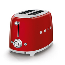Load image into Gallery viewer, White Background. Smeg Red 50s Retro 2 Slice Toaster. The body of the toaster is red with chrome letters S, M, E and G embossed on both sides. The top and base are chrome. The push down lever, defrost, reheat, stop buttons and browning knob are all chrome.
