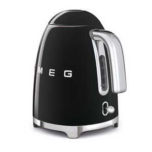 Rear side view. White Background. Smeg 50s Retro 1.7L Kettle. The body of the kettle is Black. There are chrome letters S, M, E and G embossed on each side. The lid is push button release. The spout, Handle, on/off lever and base are chrome. There is a water level window in line with the handle.