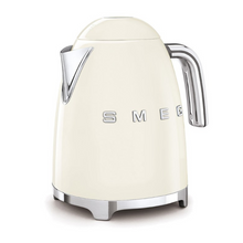 Load image into Gallery viewer, White Background. Smeg 50s Retro 1.7L Kettle. The body of the kettle is Cream. There are chrome letters S, M, E and G embossed on each side. The lid is push button release. The spout, Handle, on/off lever and base are chrome. There is a water level window in line with the handle.

