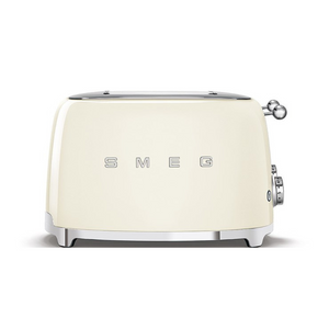 Front View. White Background. Smeg 50's Retro Cream 4 Slice Toaster. The body of the toaster is Cream with chrome letters S, M, E and G embossed on either side. The top, base, levers, knobs and buttons are all chrome. There are two push down levers, two browning knobs, two defrost, two reheat and two stop buttons. One for each set of 2 slots.
