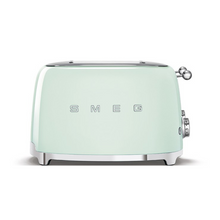 Load image into Gallery viewer, Front View. White Background. Smeg 50&#39;s Retro Pastel Green 4 Slice Toaster. The body of the toaster is Pastel Green with chrome letters S, M, E and G embossed on either side. The top, base, levers, knobs and buttons are all chrome. There are two push down levers, two browning knobs, two defrost, two reheat and two stop buttons. One for each set of 2 slots.
