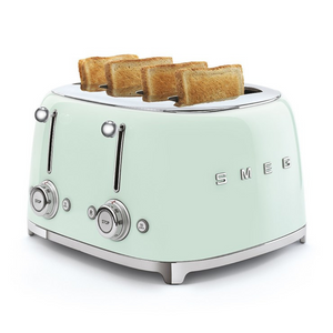 White Background. Smeg 50's Retro Pastel Green 4 Slice Toaster. The body of the toaster is Pastel Green with chrome letters S, M, E and G embossed on either side. The top, base, levers, knobs and buttons are all chrome. There are two push down levers, two browning knobs, two defrost, two reheat and two stop buttons. One for each set of 2 slots. There are pieces of toasted wholemeal bread sitting up from each slot.