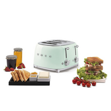 Load image into Gallery viewer, White Background. Smeg 50&#39;s Retro Pastel Green 4 Slice Toaster. The body of the toaster is Pastel Green with chrome letters S, M, E and G embossed on either side. The top, base, levers, knobs and buttons are all chrome. There are two push down levers, two browning knobs, two defrost, two reheat and two stop buttons. One for each set of 2 slots. There are breakfast items sitting around the toaster. Left to right: Jam pots, Toast and Butter, Tomatoes on the vine and a stack of toasted salad sandwiches.
