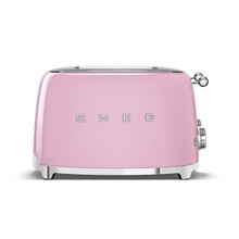 Load image into Gallery viewer, Front View. White Background. Smeg 50&#39;s Retro Pink 4 Slice Toaster. The body of the toaster is pink with chrome letters S, M, E and G embossed on either side. The top, base, levers, knobs and buttons are all chrome. There are two push down levers, two browning knobs, two defrost, two reheat and two stop buttons. One for each set of 2 slots.
