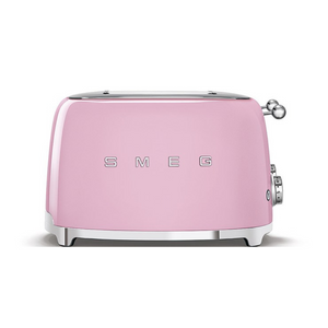 Front View. White Background. Smeg 50's Retro Pink 4 Slice Toaster. The body of the toaster is pink with chrome letters S, M, E and G embossed on either side. The top, base, levers, knobs and buttons are all chrome. There are two push down levers, two browning knobs, two defrost, two reheat and two stop buttons. One for each set of 2 slots.