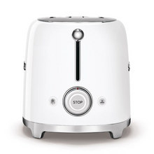 Load image into Gallery viewer, Side View. White Background. Smeg White 50s Retro 2 Slice Toaster. The body of the toaster is white with chrome letters S, M, E and G embossed on both sides. The top and base are chrome. The push down lever, defrost, reheat, stop buttons and browning knob are all chrome.
