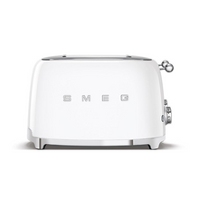 Load image into Gallery viewer, Front View. White Background. Smeg 50&#39;s Retro White 4 Slice Toaster. The body of the toaster is white with chrome letters S, M, E and G embossed on either side. The top, base, levers, knobs and buttons are all chrome. There are two push down levers, two browning knobs, two defrost, two reheat and two stop buttons. One for each set of 2 slots.

