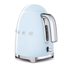 Load image into Gallery viewer, Rear Side View. White Background. Smeg 50s Retro 1.7L Kettle. The body of the kettle is Pastel Blue. There are chrome letters S, M, E and G embossed on each side. The lid is push button release. The spout, Handle, on/off lever and base are chrome. There is a water level window in line with the handle.
